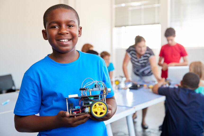 An image of a young student holding a STEAM experiment to demonstrate the type of activities students will engage in at LRCA.