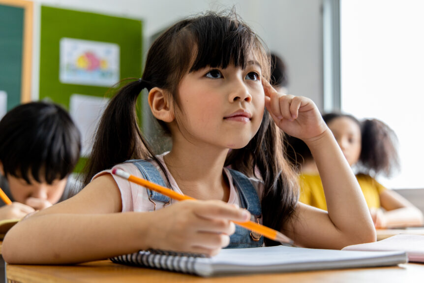 An image depicting a young student intently focusing in the classroom, which is used to demonstrate the type setting and activities students focus on at LRCA.