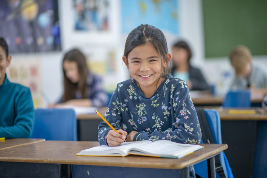 An image of a young student listening eagerly while taking a test, demonstrating the activities students engage in at LRCA.